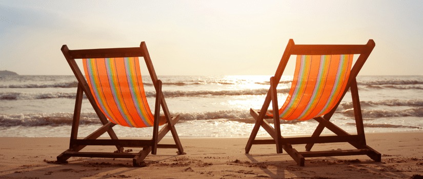 Banner Image of Two Empty Deckchairs on a Beach at Sunset