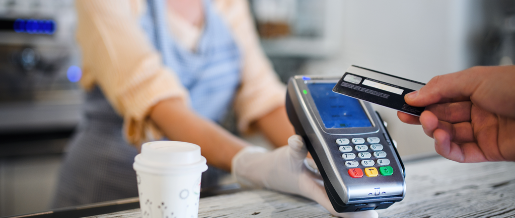 Image of customer buying coffee via contactless payment in COVID safe retail space