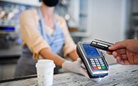 Image of customer buying coffee via contactless payment in COVID safe retail space